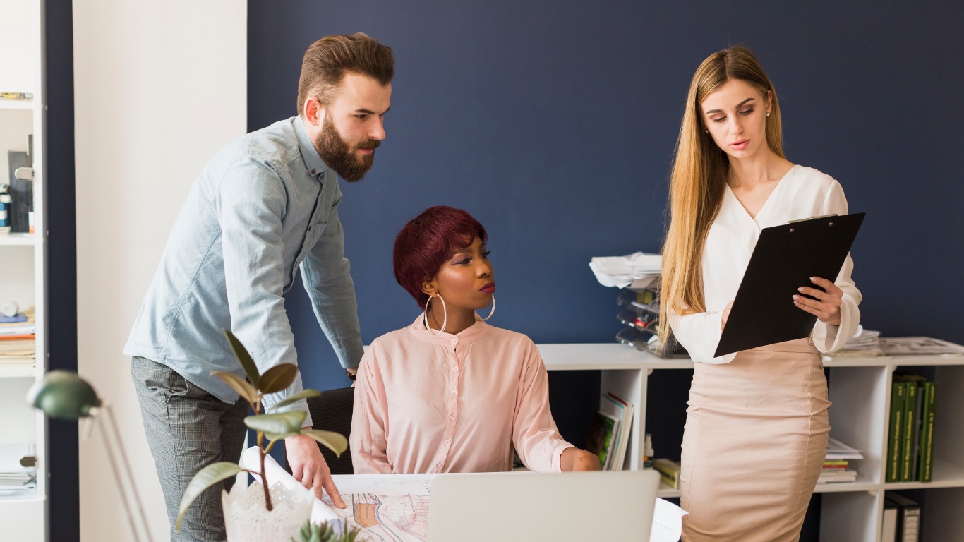 Three colleagues reviewing work together in an office